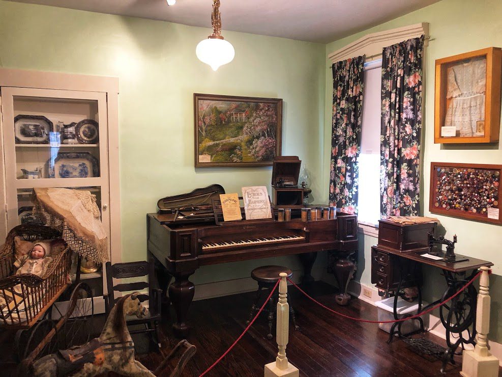 A living room with a piano and other furniture.