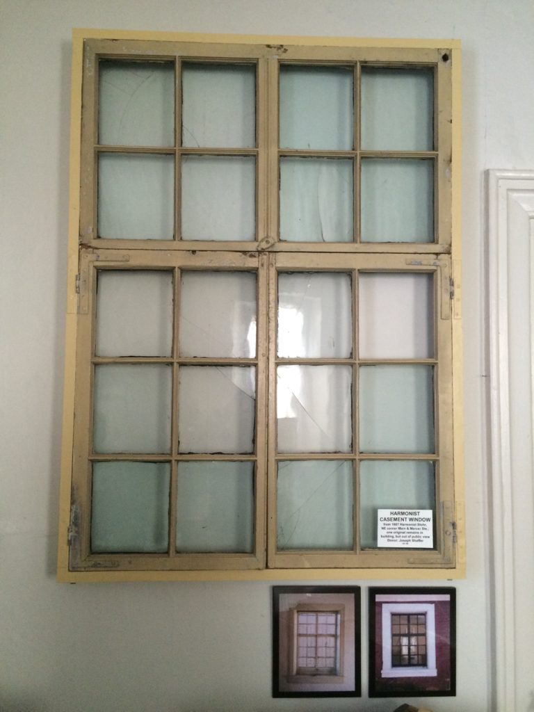 A window with glass panes on the outside of it.