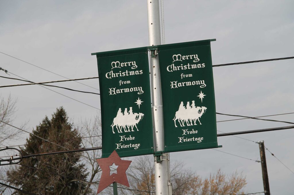 A pole with two green banners hanging from it.